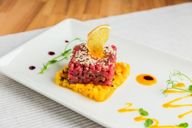 Mangolu sığır eti, susam tohumlarıyla süslenmiş ve bir dilim kurutulmuş portakal.