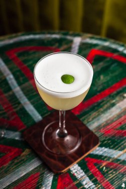 Çentikli köpüklü klasik ekşi kokteyl ve limonlu garnitürlü Nora bardağı.