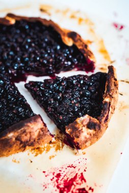 Beyaz arka planda pişirme kağıdında siyah üzümlü üzümden bir dilim yakın çekim.