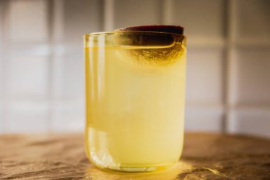 Parlak sarı bir karışım. Kayalarda buzlu. Düşük bardakta, tutku meyveleriyle süslenmiş.