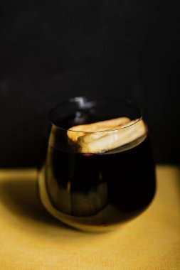 Kurutulmuş meyvelerle süslenmiş, kayaların içindeki koyu renkli bir kokteyl.