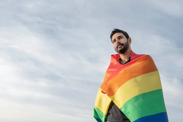 Ufukta gay bayraklı yakışıklı bir adam var. Eşcinsel, gurur, çeşitlilik kavramı