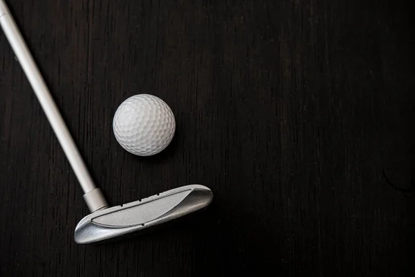 Siyah Ahşap Arka Planda Golf Topunun Yanındaki Metal Golf Sopası — Stok fotoğraf