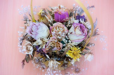 Yakından çekilmiş sepetteki pembe güllerin kuru buketi. Arkaplan, kartpostal