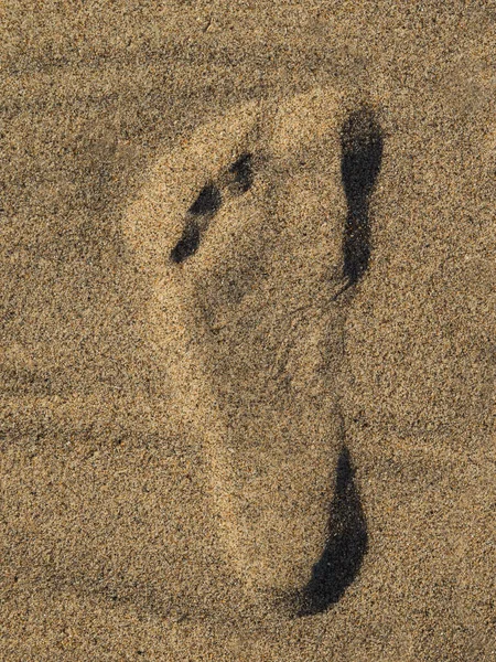 Left foot print on yellow sand