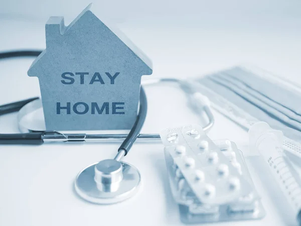 ev modeli ve tıbbi araç, tıbbi steteskop, ilaç ve şırınga, evde kalma konsepti Coronavirus veya covid-19 'un yayılmasını durdurun