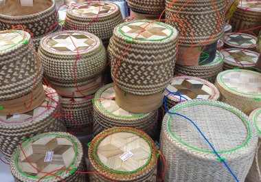 Yapışkan pişmiş glutinous pilavı tutmak için el yapımı bambu kabı. Tayland 'ın yerel pazarında satılıyor. Beyaz kağıt üzerindeki metin fiyattır.