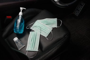Etil alkol el jeli ve araba koltuğuna yerleştirilmiş cerrahi maske, koronavirüs konsepti, covid19