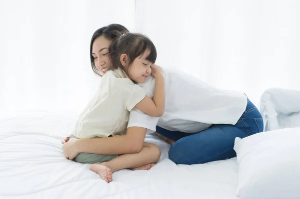 아름다운 아시아인 어머니와 껴안고 미소를 침대에서 행복을 느끼며 가족들은 멍하니 — 스톡 사진