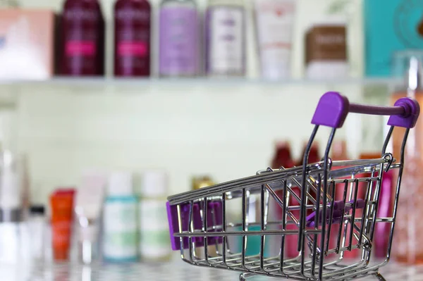 Empty shopping basket with blurred cosmetics in background