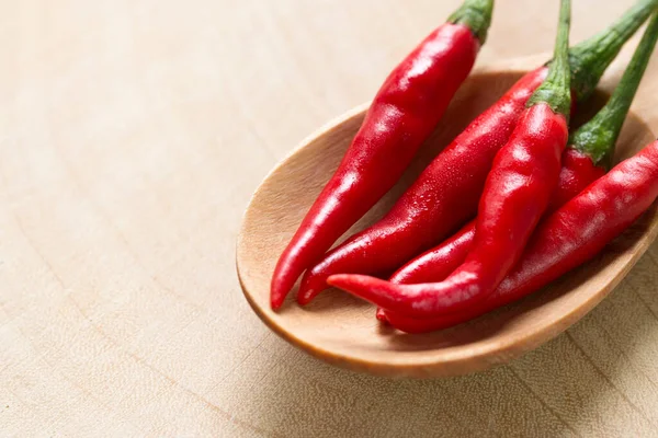 Ahşap masada kırmızı biber, yakın çekim manzaralı.