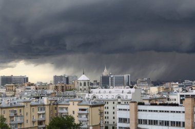 Şehir manzarası, binalar, anıtlar, çatılar, karanlık fırtınalı bir gökyüzünde çatılar ve kara yağmur bulutları. Moskova, Rusya