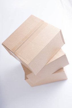 Üç kapalı dikdörtgen boş kahverengi karton kutunun kapalı yakın çekim görüntüsü beyaz arka planda.