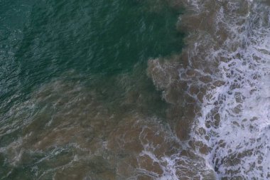 Deniz yüzeyinin turkuaz mavi su, büyük beyaz dalgalar, köpük ve sualtı kumları, güzel dokular, desenler ve şekiller oluşturan hava aracı görüntüsü. Sri Lanka