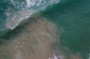 Deniz yüzeyinin turkuaz mavi su, büyük beyaz dalgalar, köpük ve sualtı kumları, güzel dokular, desenler ve şekiller oluşturan hava aracı görüntüsü. Sri Lanka