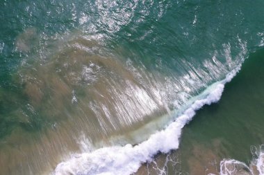 Deniz yüzeyinin turkuaz mavi su, büyük beyaz dalgalar, köpük ve sualtı kumları, güzel dokular, desenler ve şekiller oluşturan hava aracı görüntüsü. Sri Lanka