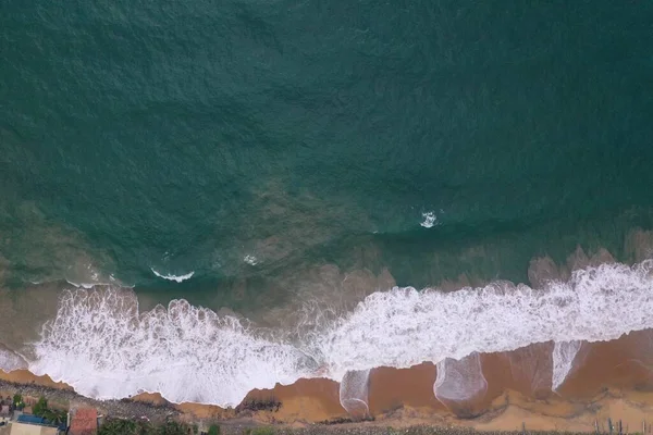 黄色の砂 黒い岩 大きな白い波と泡が美しいテクスチャ パターン 形状を形成するビーチでクラッシュと海の海岸の空中ドローンの鳥のビューショット スリランカ — ストック写真