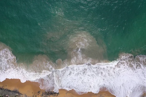 ターコイズブルーの水 大きな白い波と泡 黄色の砂を持つ空のビーチ 美しいテクスチャ パターン 形状を形成する黒い岩と海の海岸の空中ドローン鳥ビューショット スリランカ — ストック写真