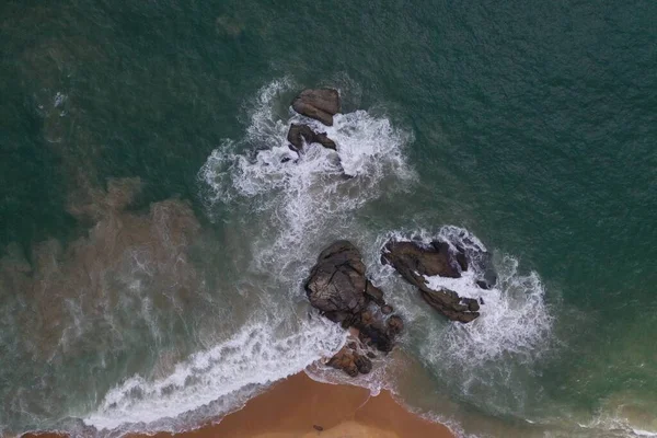 空中无人机鸟瞰海岸与碧蓝的海水 巨大的白浪和泡沫 空旷的海滩与黄色的沙子 黑色的岩石形成美丽的纹理 斯里兰卡 — 图库照片