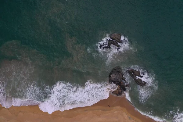 ターコイズブルーの水 大きな白い波と泡 黄色の砂を持つ空のビーチ 美しいテクスチャ パターン 形状を形成する黒い岩と海の海岸の空中ドローン鳥ビューショット スリランカ — ストック写真