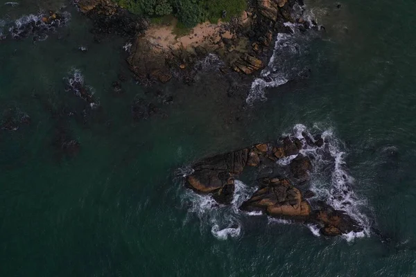 航拍的鸟瞰海面的照片 蓝绿色的海水 一个小岛 棕色的黑色岩石和石头 白色的波浪和泡沫形成美丽的纹理 斯里兰卡 — 图库照片
