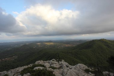 Yeşil tepelerin ve dağların manzarası, mavi gökyüzü ve büyük beyaz bulutlar. Mallorca Adası, İspanya