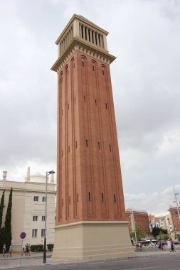 Venedik kulesinin dikey bulutlu çekimleri yapay taştan yapılmıştır. Piramitsel bakır çatılı kırmızı bir tuğla. Avinguda de la Reina Maria Cristina Bulvarı Placa d 'Espanya, Barcelona, İspanya