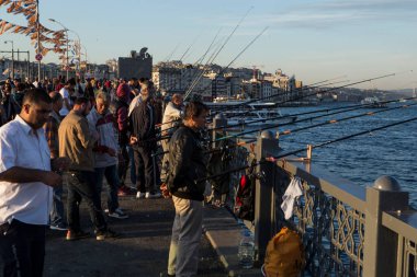 ISTANBUL / TURKEY - 30 / 05 / 2015: Galata Köprüsü 'nden Boğazı' na uzanan şeritleri ile en sevilen akşam balık avlamak için büyük bir Türk erkek balıkçı kalabalığının düzenli bir günlük toplantısı