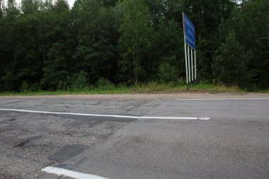 Vladimir Okrug sınırında iyi ve kötü yıpranmış hasarlı bir yol arasındaki ani farklılık ve zıtlık. Tabelada Rusça YAROSLAV İspatlama yazıyor. PERESLAV MÜZİKALİ BÖLGESİ