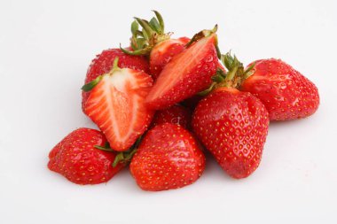 Bir grup bütünün yakın çekim görüntüsünü izole ettim ve beyaz arka planda yarı kırmızı çilekler dilimledim.