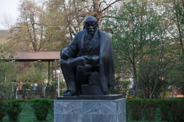MOSCOW / RUSSIA - 20 / 04 / 2019 dikey yakın çekim Vladimir Lenin 'in elinde bir defter ve kalemle oturduğu sahte bir bakır heykel.