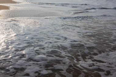 Doğal olarak doldurulmuş çerçeve, arka plan duvar kağıdı fotokopisi, pürüzsüz sarı kumsal yüzeyindeki okyanus dalgaları tarafından oluşturulan beyaz köpüğün beyaz köpüğü. Sabahın erken saatlerinde Pitiwella sahilinde, Sri Lanka