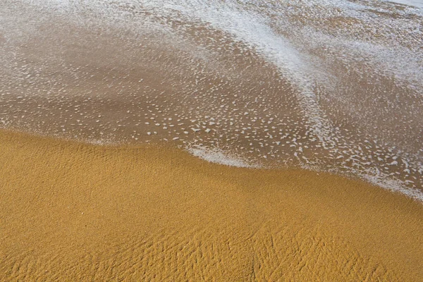 美しいフレームを閉じます海の壁紙の背景はかなりテクスチャとパターンを形成するインド海の白い泡の波と黄金のオレンジの砂のショット スリランカのPitiwellaビーチ — ストック写真