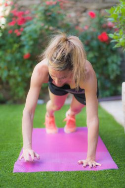 Şınav çeken genç sarışın kız.