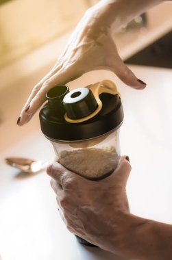 Vitiligo ile kızın elleri spordan sonra protein karışımı yapıyor.