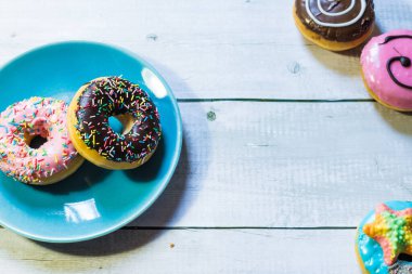 Ahşap bir masadaki mavi tabakta duran bir tabak çöreğin üst görüntüsü.