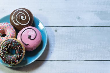 Ahşap bir masadaki mavi tabakta duran bir tabak çöreğin üst görüntüsü.