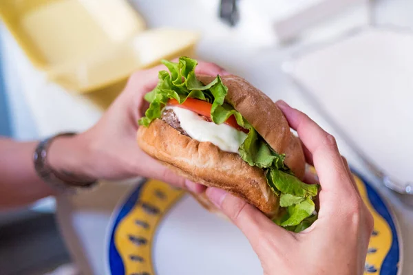 Человеческие Руки Держа Готовый Съесть Чизбургер Салатом Помидорами — стоковое фото