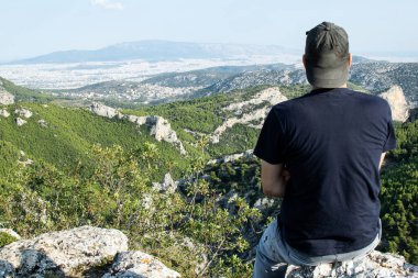 Parnitha dağının zirvesinden Atina 'nın manzarasının tadını çıkaran bir adam..