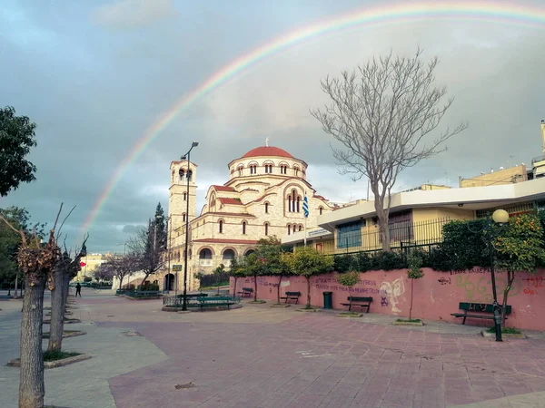 Mavi gökkuşağında inanılmaz bir gökkuşağı ve Atina şehrinde fotoğrafın merkezinde büyük bir kilise.