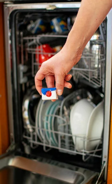 Mutfakta Bir Kadın Bulaşık Makinesinin Önünde Deterjan Tableti Tutuyor — Stok fotoğraf