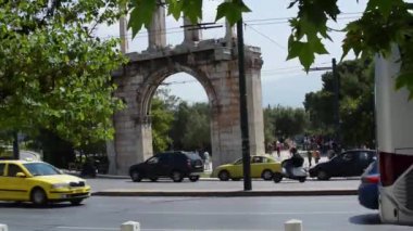 Atina, Yunanistan-26 Nisan 2019. Güneşli bir günde Olimpiyat Zeus Tapınağı önünden geçen arabalar. Turistler siteyi ziyaret ediyorlar.