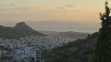 Akropolis ve Lycabettus Tepesi 'nin gökyüzünde bulutlar ve denizden geçen robotlarla ilgili hızlandırılmış videosu..