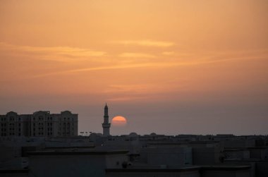 Güneş ufukta batıyor, yanında da cami minaresi var.
