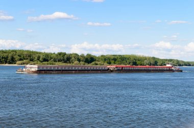 Güneşli bir havada nehirde uzun bir mavna.