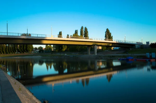 夕日の光の中 橋は川の水から反射されます — ストック写真