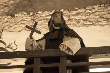 Bir ortaçağ balmumu keşişi elinde haç tutuyor. Dini görünüş.