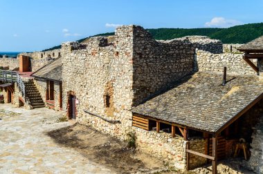 Macaristan 'daki Sumeg Ortaçağ Şatosu. İç avlu manzarası, açık mavi gökyüzü ve arka planda yaz ormanı..