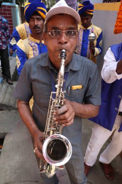 Hindistan düğününde orkestra şefi bir enstrüman çalıyor.