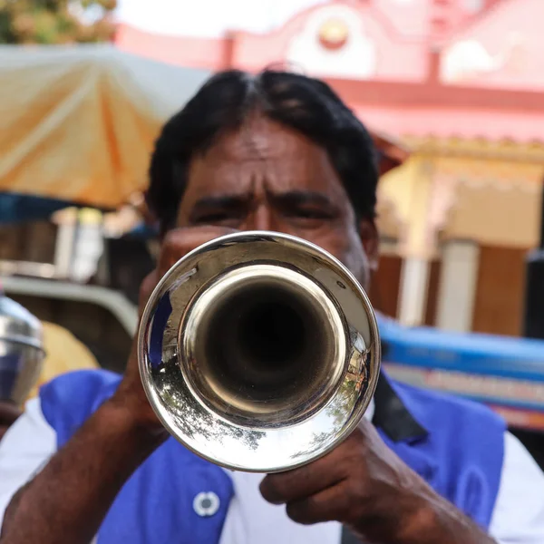 Hindistan düğününde orkestra şefi bir enstrüman çalıyor.